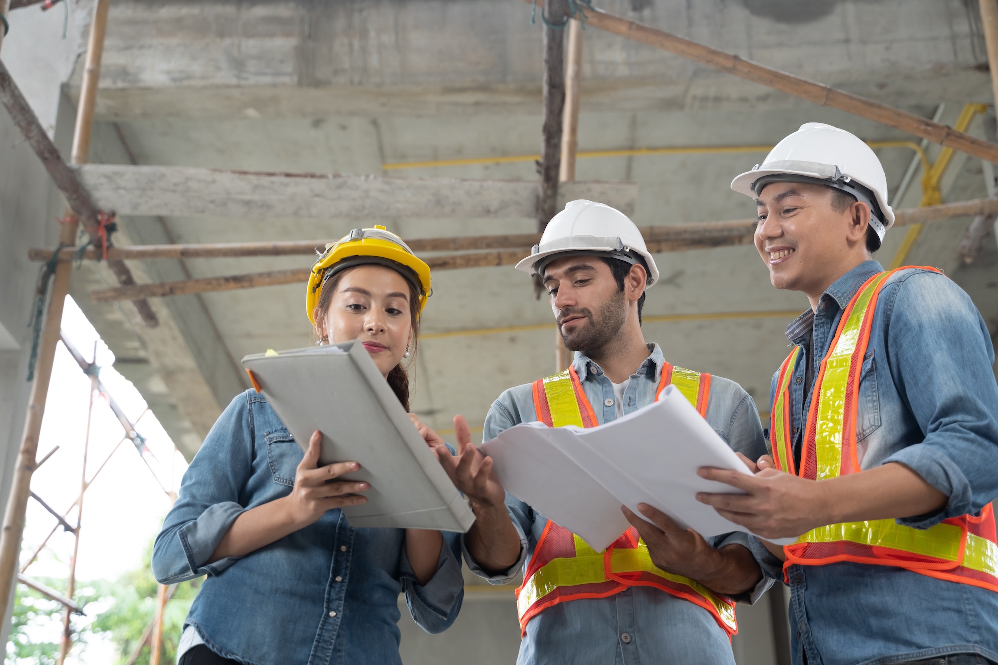 The engineering team working at building site meeting and discussing on laptop